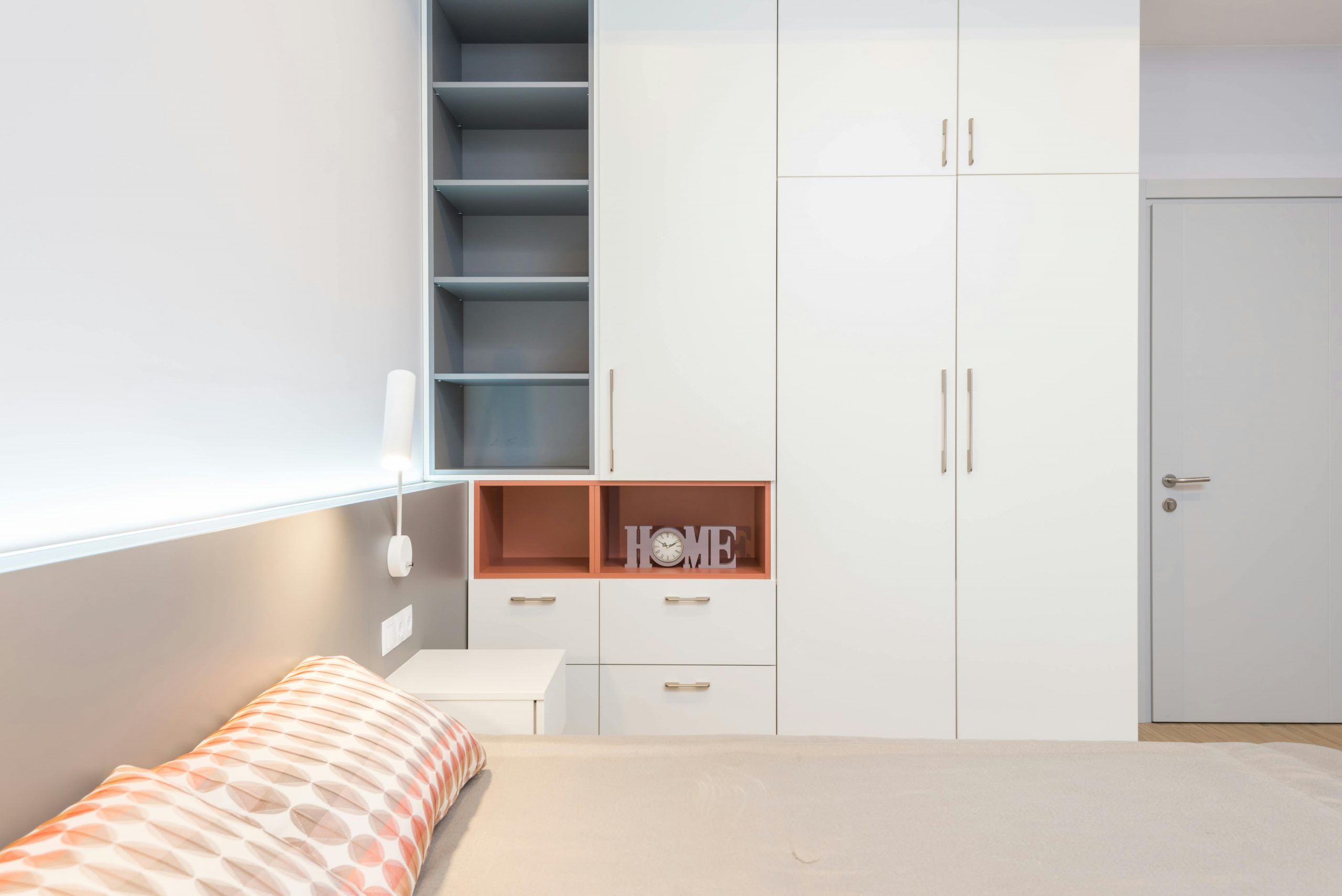 white closet next to a bed