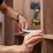 man measuring a wooden closet with a tape measure